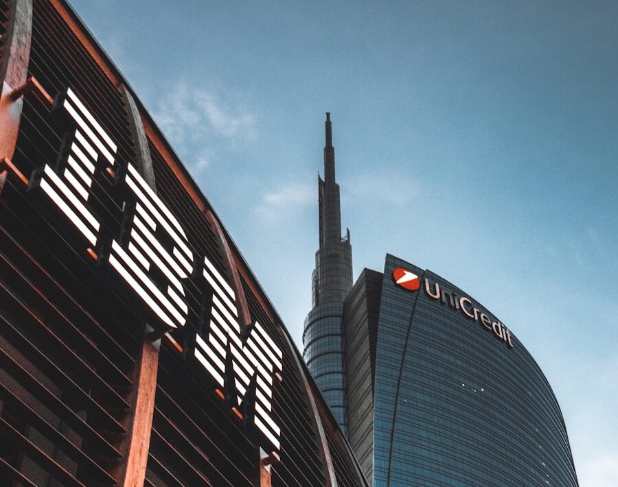 Een laag standpunt van twee gebouwen, een met het IBM-logo en een ander met het UniCredit-logo. De gebouwen hebben moderne glazen exterieurs en de lucht op de achtergrond is helder.