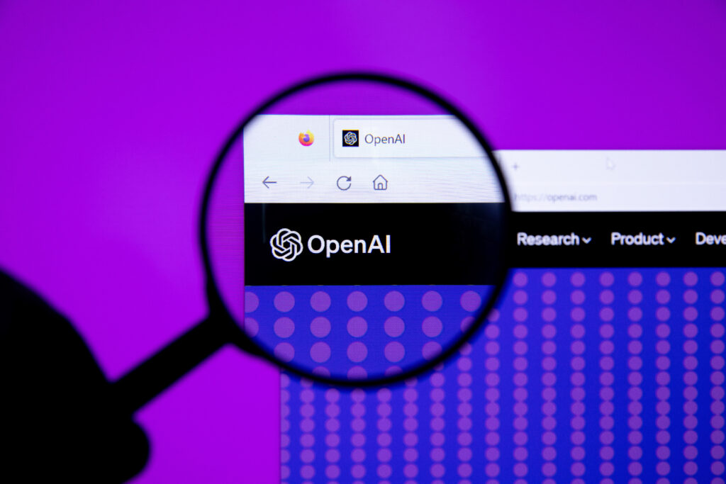 Een vergrootglas richt zich op het OpenAI-logo en de websiteheader op een computerscherm, terwijl een paarse achtergrond zichtbaar is achter de monitor.