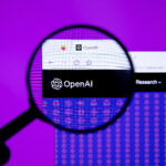 Een vergrootglas richt zich op het OpenAI-logo en de websiteheader op een computerscherm, terwijl een paarse achtergrond zichtbaar is achter de monitor.